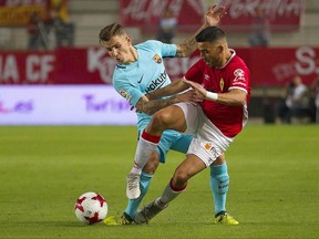 Barcelona's Lucas Digne, left, vies for the ball with Murcia's Nadjib Montes during the Copa del Rey round of 16 first leg soccer match between Murcia and Barcelona at the Nueva Condomina stadium in Murcia, Tuesday, Oct. 24, 2017. (AP Photo/Ferran Viros)