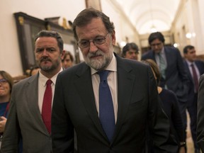 Spain's Prime Minister Mariano Rajoy leaves the main chamber of the Spanish parliament in Madrid, Wednesday, Oct. 25, 2017. Prime Minister Rajoy says the government's plans to take unprecedented control of Catalonia's key affairs and halt that region's push for independence are "exceptional" and he hopes they will not last long. (AP Photo/Francisco Seco)