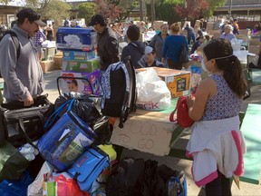 File - In this Oct. 15, 2017 file photo, wildfire evacuee Francisco Macias, a landscape worker from Santa Rosa, Calif., collects donated blankets, baby diapers and food supplies for his family at the Sonoma-Marin Fairgrounds in Petaluma, Calif. Residents in California wine country are increasingly worried about the ability to pay their bills as wildfires drag on. Macias, a landscaper in the city of Santa Rosa whose clients included a now-burned Hilton hotel, fled the fires last week. In the following days, Macias and his wife made the hard decision not to pay their mortgage when it came due. (AP Photo/Olga R. Rodriguez)