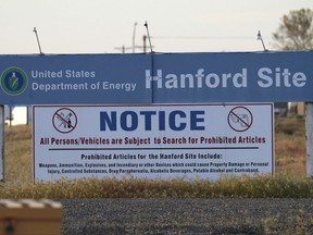 FILE - In this May 9, 2017 file photo, signs are posted by the Hanford Nuclear Reservation in Benton County, in Richland, Wash. The U.S. Department of Energy said Wednesday, Oct. 4, 2017 that workers at Hanford have started injecting grout into a partially collapsed tunnel that contains radioactive wastes left over from the production of nuclear weapons. (AP Photo/Manuel Valdes, File)