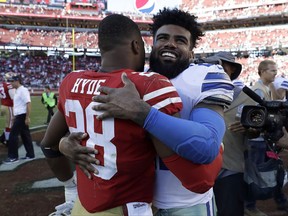 San Francisco 49ers running back Carlos Hyde (28) hugs Dallas Cowboys running back Ezekiel Elliott after the Cowboys beat the 49ers in an NFL football game in Santa Clara, Calif., Sunday, Oct. 22, 2017. (AP Photo/Marcio Jose Sanchez)