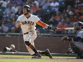 San Francisco Giants' Hunter Pence hits an RBI single off San Diego Padres relief pitcher Craig Stammen in the seventh inning of a baseball game Saturday, Sept. 30, 2017, in San Francisco. At right is Padres catcher Austin Hedges. (AP Photo/Eric Risberg)
