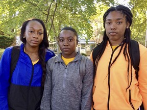 Kennesaw State University cheerleaders, from left to right,  Shlondra Young, Tommia Dean and Kennedy Town stand outside the student center on the school's campus in Kennesaw, Ga., Monday, Oct. 16, 2017. The three are part of a group of cheerleaders from the Georgia college that say they'll take a knee in the stadium tunnel when the national anthem is played at Saturday's homecoming game since their university moved them off the field after an earlier demonstration. (AP Photo/Jeff Martin)