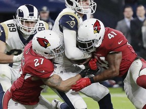 Los Angeles Rams quarterback Jared Goff (16) forces his way into the end zone to score a touchdown against Arizona Cardinals' Antoine Bethea (41) and Tyvon Branch (27) during the first half of an NFL football game at Twickenham Stadium in London, Sunday Oct. 22, 2017. (AP Photo/Matt Dunham)