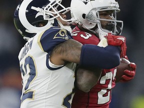 Arizona Cardinals running back Adrian Peterson (23) is tackled by Los Angeles Rams cornerback Trumaine Johnson (22) during the second half of an NFL football game at Twickenham Stadium in London, Sunday Oct. 22, 2017. (AP Photo/Tim Ireland)