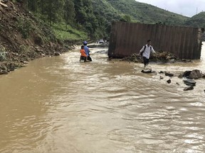 Residents wade through flood water in northern province of Son La, Vietnam Thursday Oct. 12, 2017. Floods and landslides after a tropical depression have killed over 30 people, and damaged homes and crops in northern and central Vietnam, officials said. (Huu Quyet/Vietnam News Agency via AP)