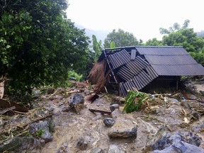 Flash floods damage a house in northern province of Hoa Binh, Vietnam on Friday Oct. 13, 2017. Floods and landslides have killed dozens of people in Vietnam since a tropical depression hit the country earlier this week, in one of its worst natural disasters in years, officials said Friday. (Nhan Sinh/Vietnam News Agency via AP)
