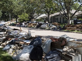 In this Sept. 7, 2017 file photo, flood damaged debris from homes lines the street in the aftermath of Hurricane Harvey in Houston.