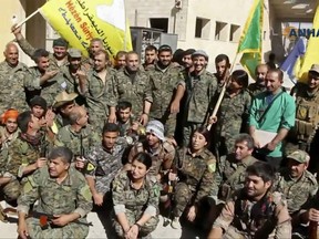 This frame grab from video released Tuesday, Oct. 17, 2017 and provided by Hawar News Agency, a Syrian Kurdish activist-run media group, shows fighters from the U.S.-backed Syrian Democratic Forces (SDF) celebrating their victory in Raqqa, Syria. U.S.-backed Syrian forces liberated the city of Raqqa from Islamic State militants on Tuesday, a senior commander for the force said, adding that clearing operations were underway to remove land mines left behind and search for the extremist group's sleeper cells. (Hawar News Agency via AP)