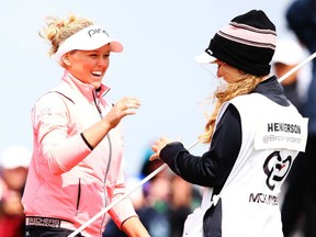 Brooke Henderson, left, of Smiths Falls, Ont. is all smiles as she celebrates winning the New Zealand Women's Open with her sister and caddie Brittany Monday in Auckland, New Zealand. The victory was Henderson's second on the LPGA tour this season and fifth overall.