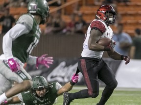 San Diego State running back Rashaad Penny (20) drags along Hawaii linebacker Jahlani Tavai (31) while running with the football in the second quarter of an NCAA college football game, Saturday, Oct. 28, 2017, in Honolulu. (AP Photo/Eugene Tanner)
