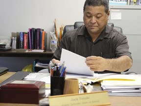 Hawaii State Public Defender Jack Tonaki looks over documents in his office in Honolulu on Thursday, Oct. 26, 2017.  Hawaii's public defender is reviewing the criminal cases handled by four Honolulu police officers and a deputy city prosecutor to uncover any possible wrongdoing after a U.S. grand jury indicted them on allegations including planting evidence, falsifying reports and lying to federal investigators in a corruption probe. (AP Photo/Jennifer Sinco Kelleher)