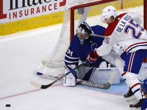 Toronto Maple Leafs goaltender Frederik Andersen, left, steers the puck away from Montreal Canadiens forward Jacob De La Rose on Sept. 25.