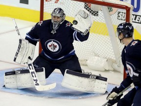 Jets goalie Connor Hellebuyck makes a glove save during first period NHL action against the Carolina Hurricanes in Winnipeg on Saturday night.
