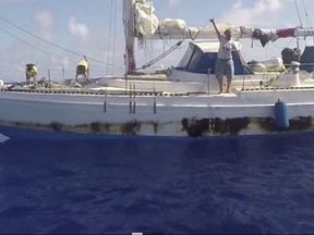 In this Wednesday, Oct. 25, 2017 still image taken from video provided by the U.S. Navy, Jennifer Appel, of Honolulu, holds up a shaka sign as rescuers approach her crippled sailboat, the Sea Nymph, after being lost at sea for months, about 900 miles southeast of Japan. Their engine was crippled, their mast was damaged and things went downhill from there for two women who set out to sail the 2,700 miles from Hawaii to Tahiti. A Taiwanese fishing vessel spotted their boat off Japan and thousands of miles in the wrong direction from Tahiti. The Navy sent the USS Ashland to their rescue. (U.S. Navy via AP)