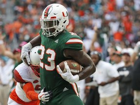 Miami tight end Christopher Herndon IV (23) is pushed out of bounds by Syracuse defensive back Juwan Dowels during the first half of an NCAA College football game, Saturday, Oct. 21, 2017 in Miami Gardens, Fla. (AP Photo/Wilfredo Lee)