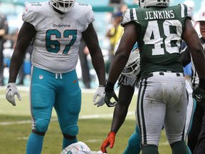 Miami Dolphins quarterback Jay Cutler (6) lies on the field after a hit by New York Jets outside linebacker Jordan Jenkins (48), during the first half of an NFL football game, Sunday, Oct. 22, 2017, in Miami Gardens, Fla. To the left is Miami Dolphins offensive tackle Laremy Tunsil (67). Cutler was injured on the play. (AP Photo/Wilfredo Lee)