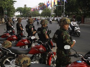 Riot police block a street near the Supreme Court in Phnom Penh, Cambodia, Tuesday, Oct. 31, 2017.  The Supreme Court on Tuesday uphold the lower court's decision to continue to detain opposition leader Kem Sokha who has been charged with treason, the latest in a series of moves to gain an advantage ahead of next year's general election. (AP Photo/Heng Sinith)