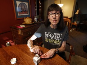 Gail Orcutt counts her medication at the kitchen table in her home, Tuesday, Oct. 17, 2017, in Pleasant Hill, Iowa. President Donald Trump's recent announcement that he's ending health subsidies for moderate-income Americans injected further uncertainty into the future of the law championed by his predecessor, Barack Obama. But confusion over open enrollment is even more pronounced in Iowa, which is seeking federal permission for a first-in-the-nation revamp of the way it administers federally mandated health care coverage and who pays for it. (AP Photo/Charlie Neibergall)