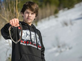 FILE - In this March 17, 2017 file photo, Canyon Mansfield, 14, holds the collar of his dog, Casey, who was killed March 16, 2017, by a cyanide-ejecting device placed on public land near his Pocatello, Idaho, home by federal workers to kill coyotes. U.S. officials have reached a tentative deal with wildlife advocates trying to stop the use of predator-killing, poisoned traps known as "cyanide bombs" that injured an Idaho teenager and killed his dog. (Jordon Beesley/Idaho State Journal via AP, file)