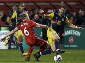 Chicago Fire midfielder Dax McCarty, left, battles for the ball with New York Red Bulls midfielder Felipe Martins during the first half of an MLS soccer playoff game, Wednesday, Oct. 25, 2017, in Bridgeview, Ill. (AP Photo/Nam Y. Huh)
