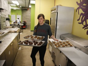 In this Friday, Sept. 15, 2017, photo, Rose Neukam juggles three sheets of cookies at Baked, in Bloomington, Ind. On Tuesday, Oct. 31, 2017, the Labor Department releases the employment cost index for the third quarter, a measure of wage and benefit growth. (Jeremy Hogan/The Herald-Times via AP)
