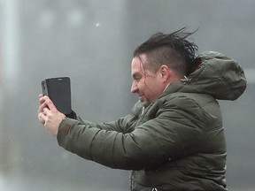 A man take selfie in the high wind at Lahinch on the west coast of Ireland  Monday Oct. 16, 2017, as the remnants of  Hurricane Ophelia begins to hit Ireland and parts of Britain.