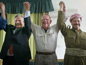 FILE - In this April 22, 2003 file photo, retired U.S. Lt. Gen. Jay Garner raises arms with then Patriotic Union of Kurdistan leader Jalal Talabani, left, and then Kurdistan Democratic Party leader Massoud Barzani in Dokan, northern Iraq. Talabani, a lifelong fighter for Iraq's Kurds who rose to become the country's president, presenting himself as a unifying father figure to temper the potentially explosive hatreds among Kurds, Shiites and Sunnis has died in a Berlin hospital at the age of 83. (AP Photo/Kevin Frayer/Pool)