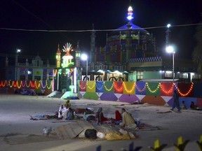 Pakistani worshippers sit outside a shrine after a bomb blast in Jhal Magsi, about 400 kilometers (240 miles) east of Quetta, Pakistan, Thursday, Oct. 5, 2017. A suicide bomber struck a Shiite shrine packed with worshippers in a remote village in southwestern Pakistan on Thursday, killing many people and leaving at least 25 wounded, a provincial government spokesman and the police said. (AP Photo/Abdul Hameed)