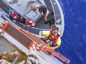 Tasha Fuiaba, an American mariner who had been sailing for five months on a damaged sailboat, climbs the accommodation ladder to board the amphibious dock landing ship USS Ashland after the Navy ship rescued two Honolulu women and their dogs Oct. 25, 2017.