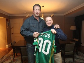 Dennis Byrd (left) and Brock Sunderland pose with the New York Jets jersey that was cut off Byrd on Nov. 29, 1992, the day he was paralyzed on the football field.