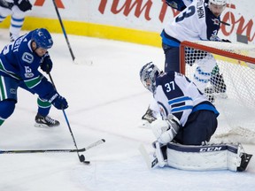 Winnipeg Jets' goaltender Connor Hellebuyck denies Vancouver Canucks' Derek Dorsett from close in during NHL action Thursday night in Vancouver. Hellebuyck had 31 saves in the Jets' 4-2 victory.