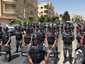 In this July 28, 2017 file photo, Jordanian riot police block the path of several hundred Jordanian protesters who chanted "Death to Israel"  after 16-year-old Mohammed al-Jawawdeh was killed, along with a Jordanian man, by an Israeli embassy security guard in Aman Jordan. The fatal July shootings cast a long shadow over traditionally low-key but strategically important bilateral ties. A Jordanian official says the relationship has been "hit hard" on all levels and that Israel's ambassador won't be allowed back unless Israel launches a serious investigation into the shooting. Israel says it's looking into the shooting it has portrayed as self-defense. (AP Photo/Omar Akour, File)