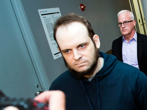 Joshua Boyle is escorted through the airport in Toronto after speaking to reporters on Friday, Oct. 13, 2017.