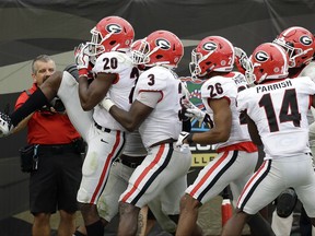 Georgia defensive back J.R. Reed (20) celebrates with teammates including linebacker Roquan Smith (3), defensive back Tyrique McGhee (26) and defensive back Malkom Parrish (14) after he recovered a Florida fumble and scored a touchdown in the second half of an NCAA college football game, Saturday, Oct. 28, 2017, in Jacksonville, Fla. Georgia won 42-7. (AP Photo/John Raoux)
