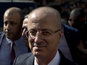 Palestinian Prime Minister Rami Hamdallah is surrounded by security during his visit to the Shejaiya neighborhood in Gaza City, Monday, Oct. 2, 2017. Hamdallah is in Gaza for the most ambitious attempt yet to end the 10-year rift between rival Palestinian factions Fatah and Hamas.(AP Photo/ Khalil Hamra)