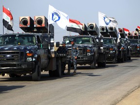 Members of the Iraqi forces stand next to rocket launchers heading to Kurdish peshmerga positions on October 15, 2017, on the southern outskirts of Kirkuk. The presidents of Iraq and Iraqi Kurdistan held talks to defuse an escalating crisis.