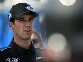 Austin Theriault, points leader for the ARCA racing series, waits by his car during qualifying for the Kansas 150 auto race at Kansas Speedway Friday, Oct. 20, 2017, in Kansas City, Kan. (AP Photo/Ed Zurga)