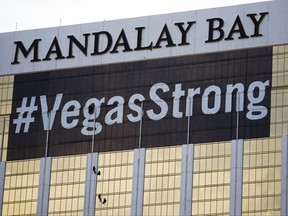 FILE - In this Monday, Oct. 16, 2017, file photo, workers install a #VegasStrong banner on the Mandalay Bay hotel and casino in Las Vegas. Stephen Paddock opened fire from the hotel on an outdoor country music concert, killing 58 and injuring hundreds. Las Vegas' efforts to rebrand itself since the shooting show just how difficult it can be for organizations to hit the right tone after a deeply tragic event. The city put its famous "What happens here, stays here" slogan on hold, and its initial ad campaign after the attack won praise for its sensitivity. But a national TV commercial that features real social media posts from after the shooting is getting more mixed reviews, with some calling it tacky.(AP Photo/John Locher, File)