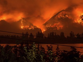 FILE - This Sept. 4, 2017 file photo provided by KATU-TV shows a wildfire seen from Stevenson, Wash., across the Columbia River, burning in the Columbia River Gorge above Cascade Locks, Ore. Charges have been brought against a 15-year-old boy who allegedly used fireworks to start the blaze. The Hood River County District Attorney said in a statement Thursday, Oct. 19 that the charges in juvenile court include reckless burning, depositing burning materials on forest lands and recklessly endangering other persons. (Tristan Fortsch/KATU-TV via AP, File)