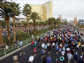 FILE - In this Dec. 5, 2010 file photo, runners fill the Las Vegas Strip in the shadow of the Mandalay Bay hotel, top left, during the Las Vegas Rock 'n' Roll Marathon in Las Vegas. The upcoming Las Vegas Rock 'n' Roll Marathon on Nov. 12, has a new start line and race festival grounds.  The race will start in front of the New York-New York resort on the Las Vegas Strip, about 1 mile (1.6 kilometers) north of last year's start near the Mandalay Bay. (AP Photo/Isaac Brekken, File)