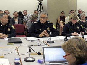 FILE- In this Sept. 30, 2014, file photo, Honolulu Police Chief Louis Kealoha, center, addresses Hawaii lawmakers during hearing in Honolulu. Kealoha the former Honolulu police chief who retired amid a federal investigation into department-wide corruption has been indicted and arrested. An assistant U.S. attorney says Kealoha and his wife, Katherine, a deputy city prosecutor, surrendered to federal authorities outside their home Friday, Oct. 20, 2017. What started as a curious case about a stolen mailbox has led to arrests of current and former officers accused of falsifying documents and altering evidence. (AP Photo/Jennifer Sinco Kelleher, File)