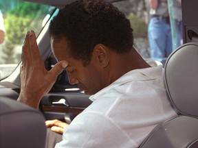 FILE - In this June 13, 1994, file photo, former pro running back O.J. Simpson hangs his head as he sits in his attorney's car after being questioned by Los Angeles Police into the death of his ex-wife, Nicole Brown Simpson. The bodies of the 35-year-old woman and an unidentified 26-year-old man, apparent stabbing victims, were discovered after midnight Sunday in her Los Angeles area home. (AP Photo/Nick Ut, File)