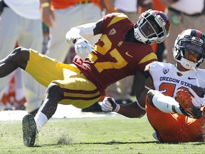 Oregon State wide receiver Seth Collins, right, gets stops by Southern California cornerback Ajene Harris, left, at the line of scrimmage, but a personal foul advances the ball during the first half of an NCAA college football game in Los Angeles, Saturday, Oct. 7, 2017. (AP Photo/Alex Gallardo)