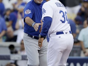 Chicago Cubs manager Joe Maddon, left, greets Los Angeles Dodgers manager Dave Roberts before Game 1 of baseball's National League Championship Series in Los Angeles, Saturday, Oct. 14, 2017. (AP Photo/Matt Slocum)