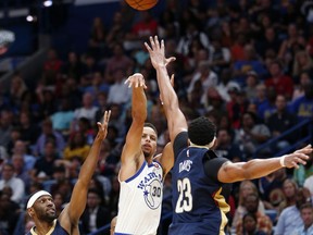 Golden State Warriors guard Stephen Curry (30) shoots between New Orleans Pelicans forward Anthony Davis (23) and guard Ian Clark (2) in the first half of an NBA basketball game in New Orleans, Friday, Oct. 20, 2017. (AP Photo/Gerald Herbert)