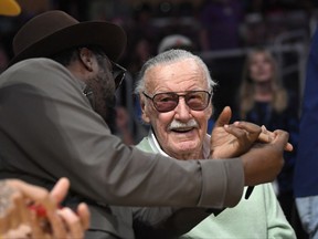 Famed comic book creator Stan Lee, right, talks with singer will.i.am of the Back Eyed Peas during the first half of an NBA basketball game between the Los Angeles Lakers and the Toronto Raptors, Friday, Oct. 27, 2017, in Los Angeles. (AP Photo/Mark J. Terrill)