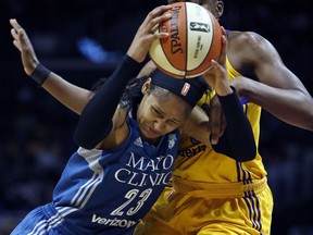 Minnesota Lynx forward Maya Moore, left, drives to the basket and picks up a foul on Los Angeles Sparks forward Nneka Ogwumike during the first half in Game 4 of the WNBA basketball finals, Sunday, Oct. 1, 2017, in Los Angeles. (AP Photo/Alex Gallardo)