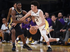 Los Angeles Lakers guard Lonzo Ball, right, moves the ball around New Orleans Pelicans guard E'Twaun Moore during the first half of an NBA basketball game in Los Angeles, Sunday, Oct. 22, 2017. (AP Photo/Kelvin Kuo)