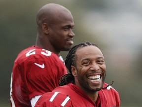 Wide receiver Larry Fitzgerald, right, and running back Adrian Peterson of the Arizona Cardinals laugh during an NFL training session at the London Irish rugby team training ground in the Sunbury-on-Thames suburb of south west London, Thursday, Oct. 19, 2017. The Arizona Cardinals are preparing for an NFL regular season game against the Los Angeles Rams in London on Sunday. (AP Photo/Kirsty Wigglesworth)